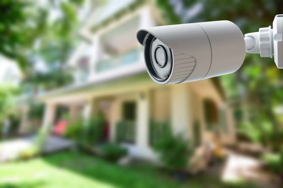 A luxury home with a video surveillance camera outdoors.
