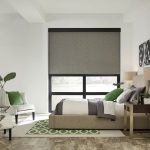 Modern bedroom with a large Lutron motorized shade on the window.